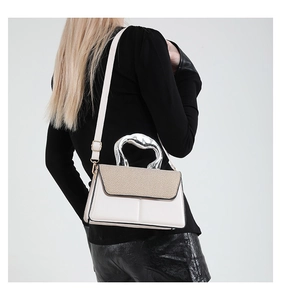 Detail of the unique silver sculptural metal handle and cream leather on the handbag
