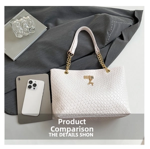 Detail of white woven tote bag with gold chain strap, deer charm and metal buckle
