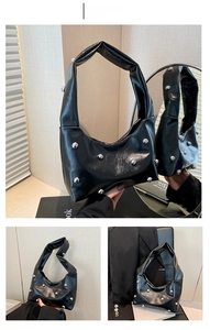 Detail view of black crescent bag featuring silver studs and soft pleated faux leather texture