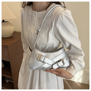 Silver retro shoulder bag with metallic texture and large gold buckles shown on a model