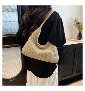 Hobo straw beach bag with smooth leather trim shown in a cozy home interior scene