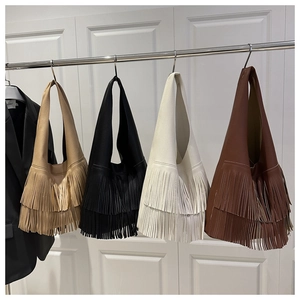 Detailed view of large tassel shoulder bags in black, khaki, white, and brown colors