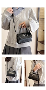 Close-up of black glossy PU leather handbag with silver metal bow and detachable strap
