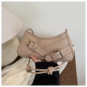 Close-up of beige moon bag showing dual buckle detail and knotted shoulder strap