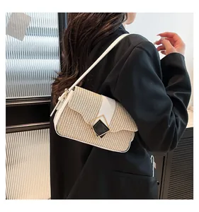 Détail d'un sac à bandoulière en paille avec bordure en cuir blanc et boucle vintage