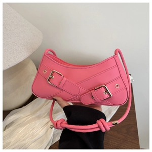 Detail of hot pink Y2K underarm bag with decorative gold buckle straps on matte PU leather