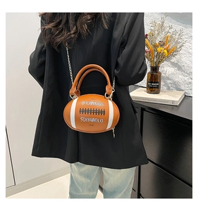 Detail of creative rugby-shaped crossbody bag with metal chain and leather stripes
