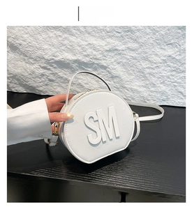 Detail of white round mini bag with lychee texture PU and embossed SM logo