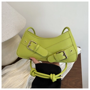 Detailed close-up of grass green crescent bag featuring stylish metal buckles and knotted strap
