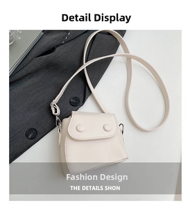 Macro shot of minimalist cream mini square crossbody bag with decorative round buttons