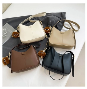 Détail de sacs selle minimalistes en quatre couleurs avec boucle mode et pendentif peluche