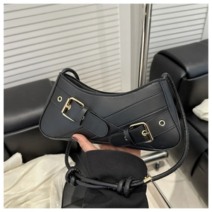 Detail of black vintage square bag with metal buckles and knot shoulder strap
