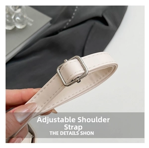 Detail of off-white leather adjustable shoulder strap with silver metal buckle