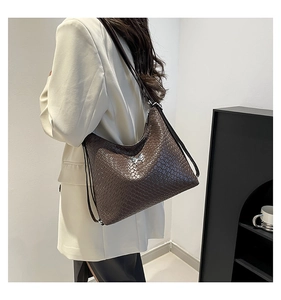 Detail of dark brown faux crocodile leather hobo bag with silver butterfly buckle