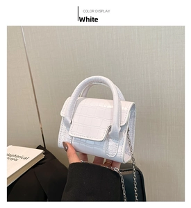 Detail of white crocodile pattern micro handbag with silver chain and handle
