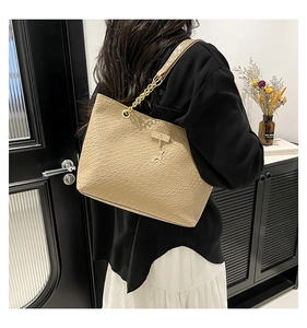 Beige woven texture tote bag with gold deer pendant and elegant chain shoulder strap