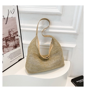 Close-up of beige woven mesh tote bag on a minimalist display with artistic posters