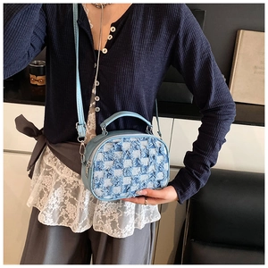 Close-up of light blue denim crossbody bag featuring frayed checkerboard pattern and texture