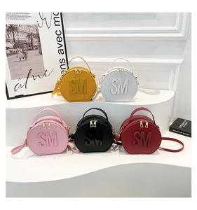 Detailed view of circular mini handbags in five colors featuring SM letter decoration