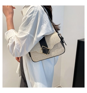Détail du sac bandoulière tissé beige avec boucle géométrique noire et fine lanière en cuir
