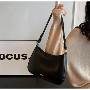Detail of black glossy hobo bag with gold adjustable buckle and brand logo