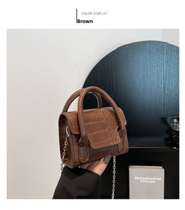 Close-up of brown crocodile texture mini square bag with silver metal chain strap