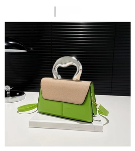 Detail of green handbag with woven texture flap and metallic silver ring handle