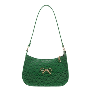 Sac sous le bras vert avec gaufrage circulaire et détail de nœud doré sur fond blanc