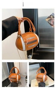 Detail of rugby-shaped brown leather bag with white stripes and gold chain strap