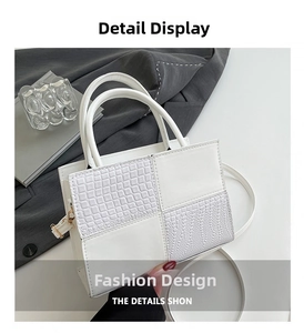 Détail de la texture crocodile blanche et ferrures dorées du grand sac bandoulière