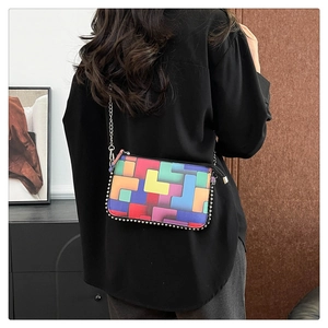 Détail d'un sac bandoulière géométrique coloré avec bordure en perles et chaîne argentée