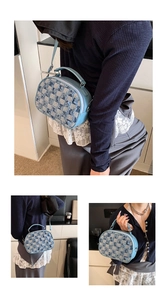 Nahaufnahme der hellblauen Denim-Karotasche mit Fransenkanten und vielseitigen Trageriemen