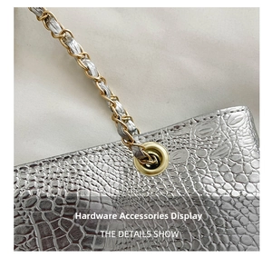 Close-up of silver crocodile embossed texture with gold chain strap detail
