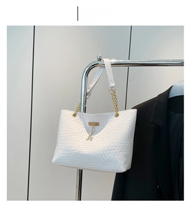 White faux crocodile tote bag with gold deer charm and chain strap detail closeup