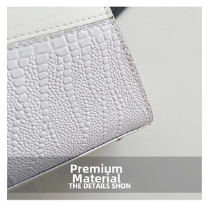 Gros plan sur la texture du cuir blanc embossé crocodile de ce sac à main chic