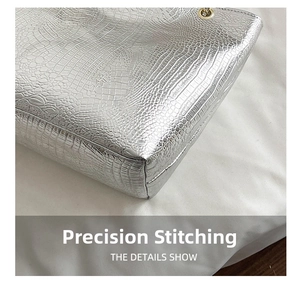 Detail of silver crocodile pattern bag showing precision stitching and metallic finish