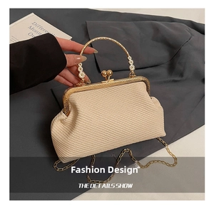 Detail of beige woven shell bag with gold engraved handle and ball clasp closure