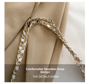 Detail of dual-tone metal chain and grey leather woven shoulder strap on a tote bag