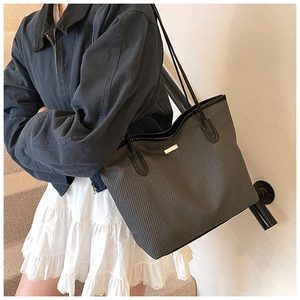 Side view of houndstooth tote bag with leather trim on model in modern indoor setting