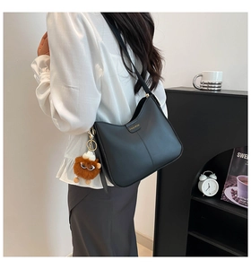 Détail du sac à bandoulière demi-lune en cuir PU noir avec logo doré élégant