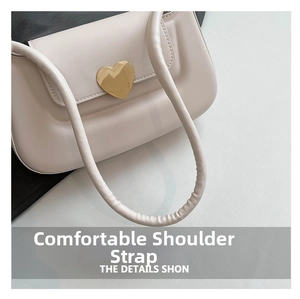 Close-up of cream underarm bag showing comfortable strap and gold heart buckle detail