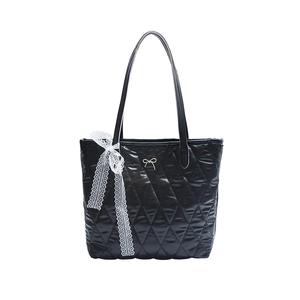 Sac cabas noir matelassé avec surpiqûres en losange, logo en métal et nœud en dentelle