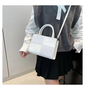 Détail du sac à main blanc avec texture crocodile alternée et panneaux au fini lisse