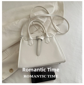 Detail view of cream-colored PU leather handbag with pebble texture and metal buckle
