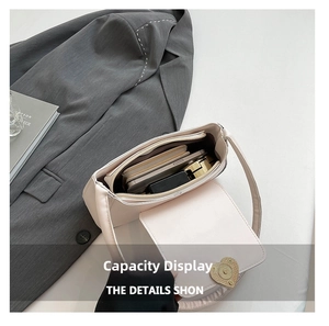 Interior view of beige heart-buckle shoulder bag showing storage space for phone and wallet