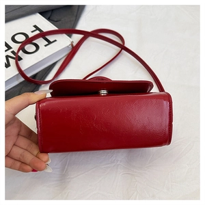 Macro view of the rectangular base structure of this red oil wax leather crossbody bag
