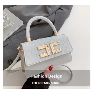 Détail du rabat pailleté argenté et boucle dorée sur le sac à main en cuir