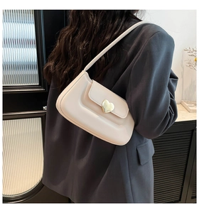 Vista laterale dettagliata della borsa sottobraccio in pelle bianco avorio con fibbia a cuore