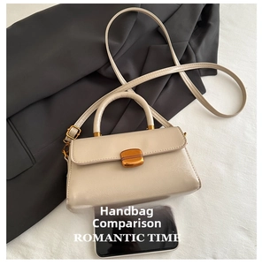 Detailed view of beige vintage square bag with gold buckle and adjustable strap