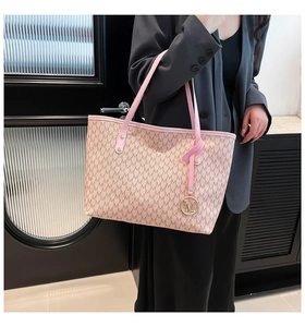 Detail of light pink tote bag with M-pattern logo, thin straps and gold metal charm